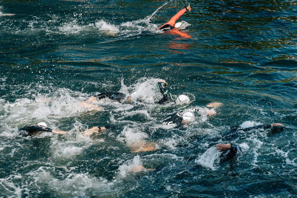 Personen schwimmen bei Triathlon