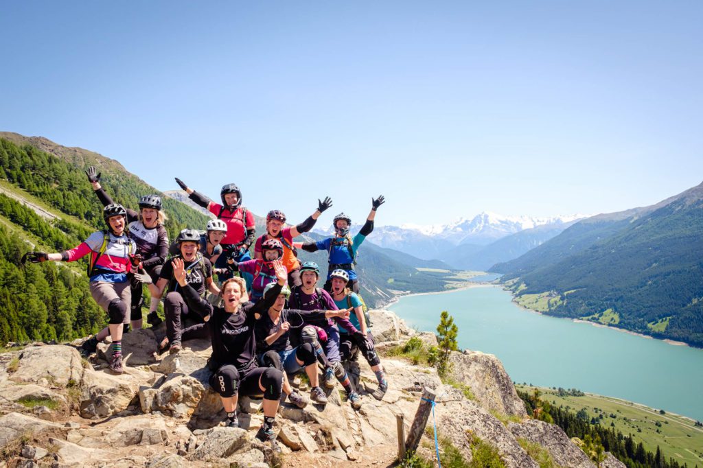 Gruppe Frauen auf Fels vor Reschensee jubelt