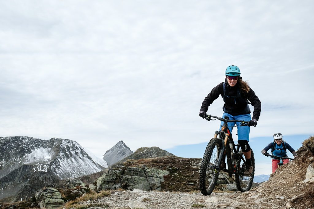 Mountainbikerin vor verschneiten Bergen