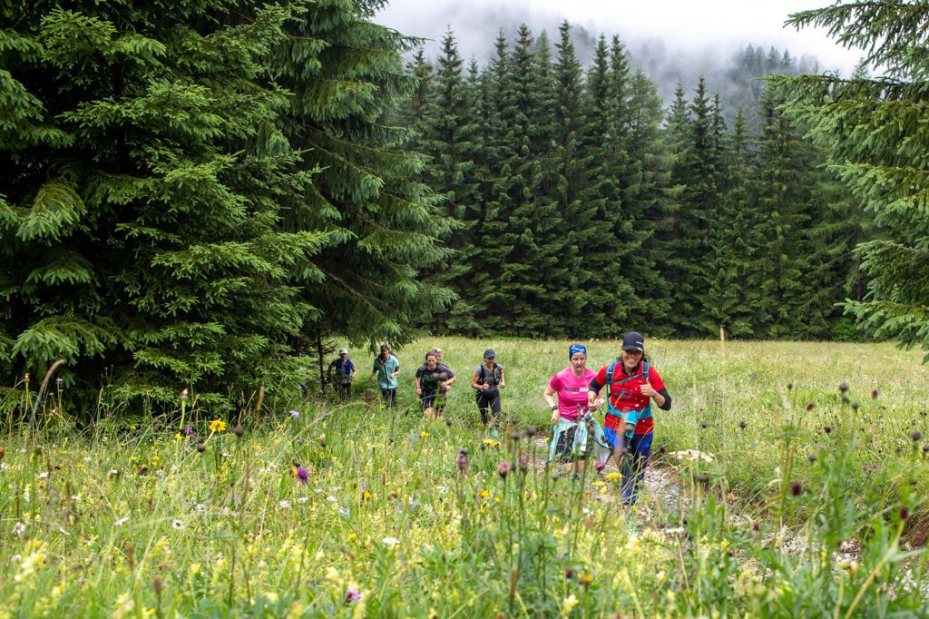 Frauen im Regen auf Trailrun über Bergwiese