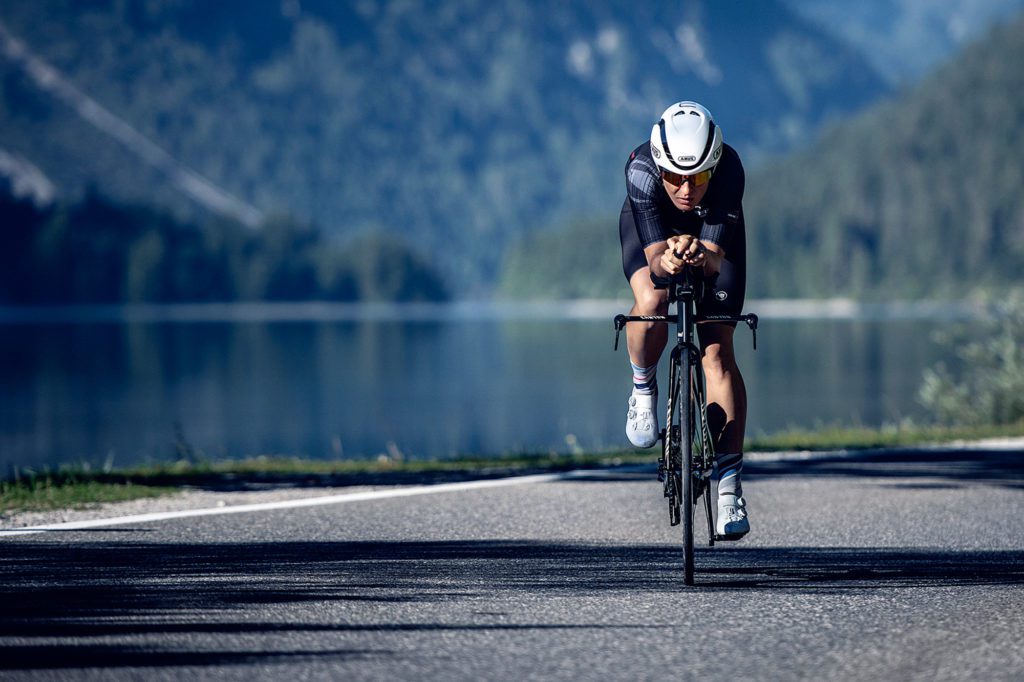 Frau auf Triathlonrad mit GameChanger Triathlonhelm von Abus vor See