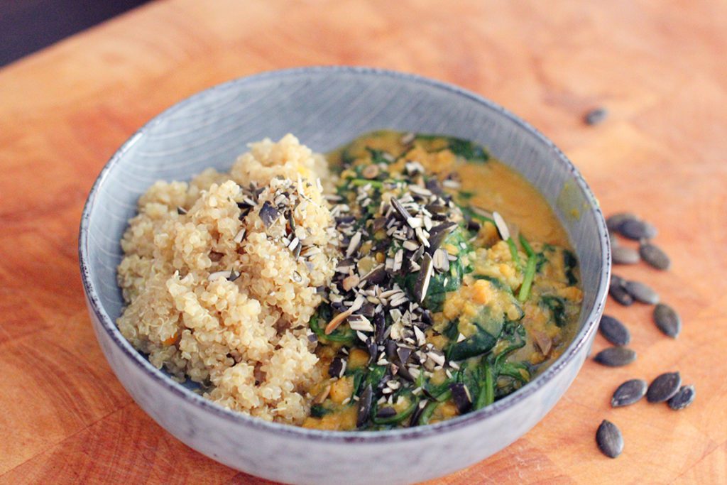 Linsendal mit Quinoa und Spinat in Bowl
