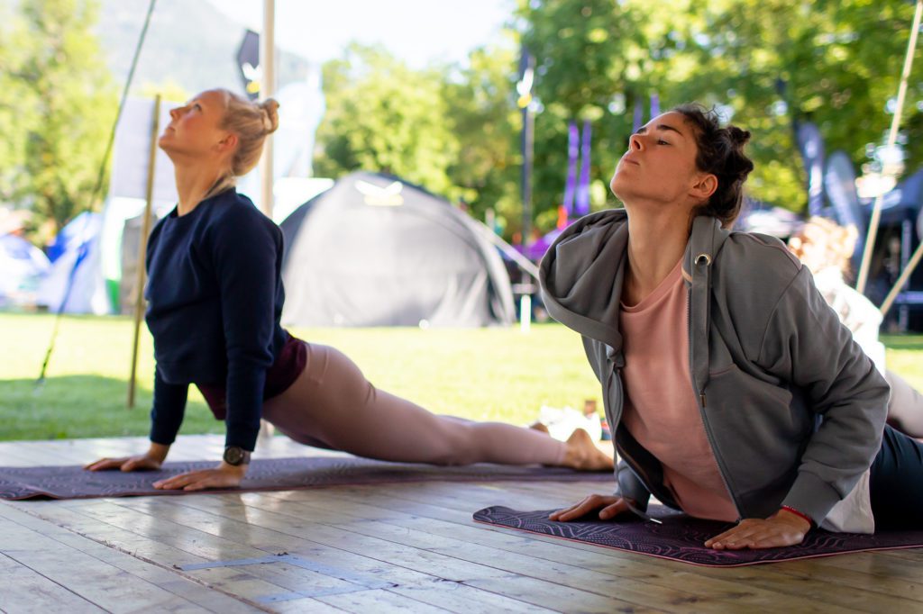 Zwei Frauen machen den Herabschauenden Hund beim Yoga