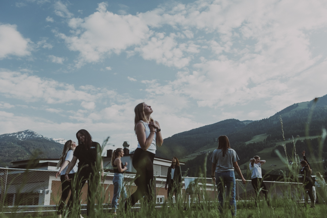 Frauen beim Tanzen auf einer Terrasse in den Bergen