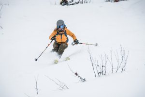 Freeriderin mit oranger Jacke abseits der Piste