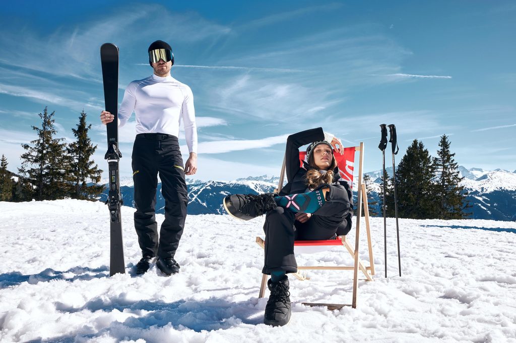 Frau und Mann stehen im Schnee und blicken in Kamera