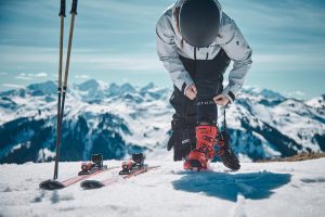 Frau zieht sich Skischuhe an und zeigt STOX Skisocken